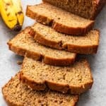 Chai banana bread sliced with a banana next to it.