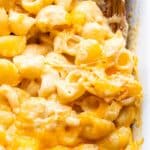 Baked Macaroni and Cheese in a white casserole dish with a wooden serving spoon.