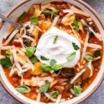 Overhead photo of vegetarian lasagna soup with melted mozzarella cheese and a big dollop of ricotta cheese on top.