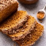Vegan Pumpkin Streusel Bread with three slices cut and lying in front of the loaf.