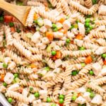 Overhead photo of Chicken Pot Pie Pasta in a metal pan with a wooden spoon in the pan.