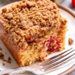 A slice of Cranberry Orange Coffee Cake on a white plate with a fork
