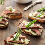 Steak Crostini with Blue Cheese Sauce | Crostini topped with a creamy blue cheese sauce and juicy slices of steak!