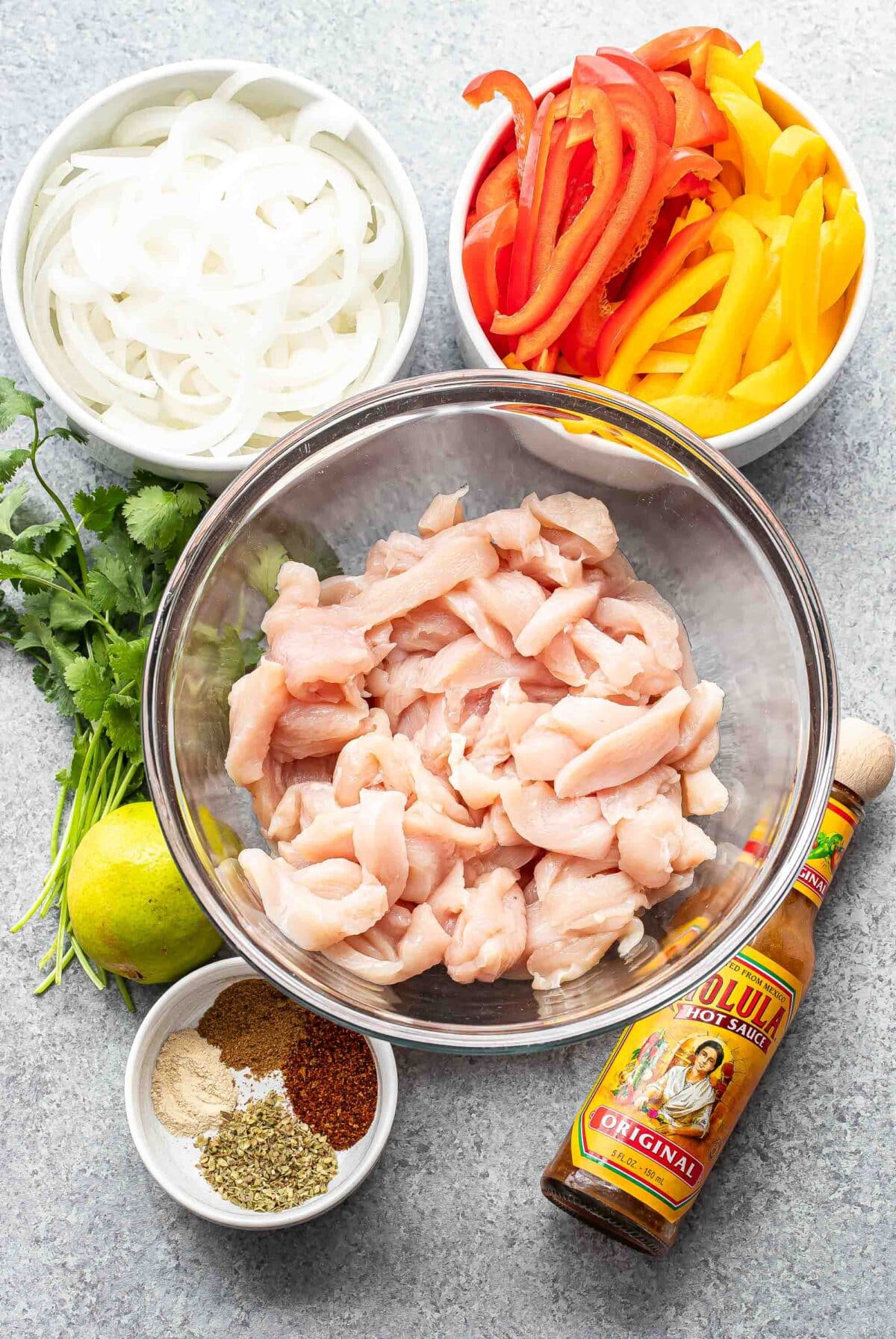 Ingredients used to make chicken fajitas in bowls.