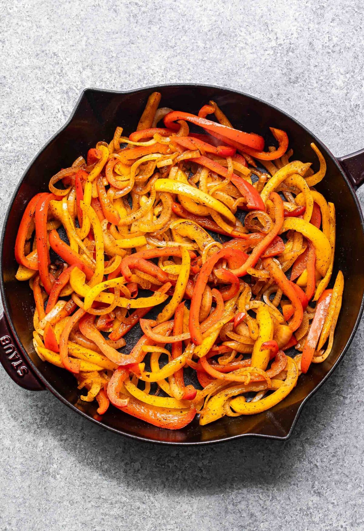 Sautéed peppers and onions in a skillet.
