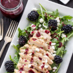 Grilled Chicken and Goat Cheese Salad with Blackberry Vinaigrette on rectangular white plate