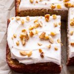 Square edge piece of the Banana Snack Cake with Cinnamon Cream Cheese Frosting topped with chopped walnuts.