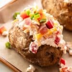 Loaded baked potato topped with cottage cheese, veggies, and bacon.