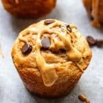 Peanut butter banana muffin with chocolate chips drizzled with peanut butter.