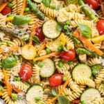 Pasta Primavera in a pan. The pasta has asparagus, zucchini, tomatoes, carrots, and peas.