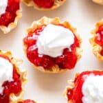 Closeup photo of no bake strawberry pie bites in phyllo shells topped with whipped cream.