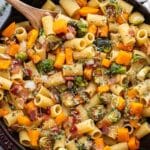 Bacon, Brussels Sprouts, Butternut Squash Pasta in a skillet with a wooden serving spoon.