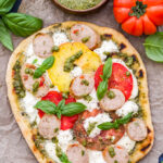 Keep the heat out of the kitchen and try grilling your next pizza! This Grilled Tomato, Basil, Pesto Pizza with Chicken Sausage, Mozzarella and Ricotta not only tastes amazing, but it's easy to make! Perfect for dinner or an appetizer for your next party.