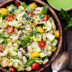 Grilled Zucchini, White Bean, Tomato and Tortellini Pasta Salad in wooden bowl