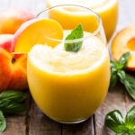 Peach Basil Frosé in glass with a peach and basil leaf garnish