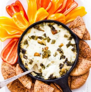 Looking for a healthier version of spinach artichoke dip? Look no further than this Baked Green Chile Spinach Artichoke Hummus Dip! All the classic flavors combined with green chiles, creamy hummus and plenty of melted cheese. This dip will be a total crowd pleaser at your next party!