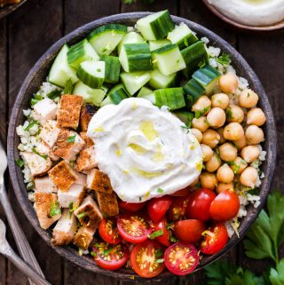 These Healthy Chicken Shawarma Bowls need to be in your weeknight dinner rotation! Fresh vegetables, chickpeas, seasoned chicken and the most amazing spiced yogurt sauce. Keep it low-carb with cauliflower rice or substitute with your favorite whole grain for a complete balanced meal!