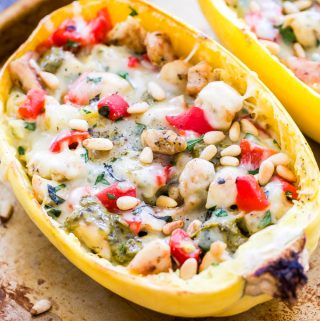 Comfort food gets lightened up thanks to spaghetti squash! You'll love this gluten-free, cheesy, Pesto Chicken and Roasted Red Pepper Stuffed Spaghetti Squash and you won't miss the pasta! #spaghettisquash #lowcarb #pesto #chicken #glutenfree #recipe #healthydinner