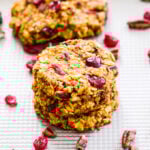 Pumpkin Cranberry Pecan Breakfast Cookies stacked on top of each other on a baking sheet.