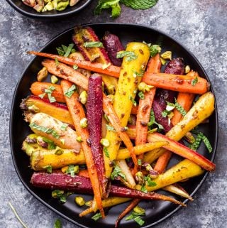Fragrant, sweet, warmly spiced Garam Masala and Honey Roasted Carrots are the perfect side dish to serve with dinner. Topped with chopped pistachios and fresh mint, they're sure to be your new favorite way to eat carrots! #carrots #garammasala #sidedish #glutenfree #healthyrecipe #paleo #honey