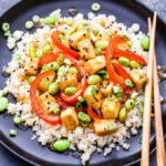 Orange Tofu and Edamame Stir-Fry is perfect for an easy, meatless dinner. Crisp tofu, sweet red bell peppers and protein packed edamame are coated in a fresh and flavorful orange sauce. You'll love this healthy, one pan dinner!  #tofu #orange #edamame #stirfry #takeout #healthyrecipe #dinner #glutenfree #vegetarian