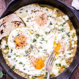 Salsa Verde Baked Eggs are perfect a simple and satisfying breakfast or dinner! Easy homemade salsa verde topped with perfectly baked eggs, queso fresco and served with warm corn tortillas. #eggs #salsaverde #glutenfree #breakfast #vegetarian