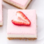 Strawberry Greek Yogurt Cheesecake Bars are perfect for spring! You'll never suspect that these creamy, rich, layered bars were lightened up! #cheesecake #greekyogurt #strawberry #dessert #easter