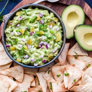 Green Chile Guacamole is the perfect way to add a little heat and smoky flavor to traditional guacamole. Serve with chips, on tacos or any of your favorite Mexican dishes! #guacamole #greenchile #dip #mexicanfood #avocados