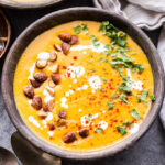 This Creamy Red Lentil Butternut Squash Soup is a healthy and delicious vegetarian meal that's packed with protein and nutrients! Top it with smoked almonds, cilantro and a drizzle of Greek yogurt for an easy weeknight dinner. #soup #lentils #butternutsquash #vegetarian #easyrecipe #healthydinner