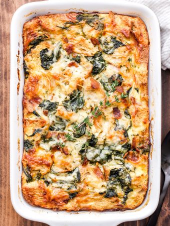 This Spinach, Bacon and Cheese Strata will be a fantastic addition to your next holiday brunch or weekend breakfast! Make it the night before and bake it in the morning for a stress free, hearty egg dish everyone will enjoy! #strata #eggs #bacon #spinach #bread #brunch #breakfast #christmas #thanksgiving #breakfastcasserole