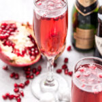 Pomegranate French 75 is in a champagne flute.