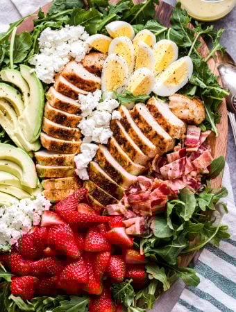 California Cobb Salad with a touch of spring! You'll love the addition of sweet strawberries, tangy goat cheese and a lemon vinaigrette to brighten of this classic main dish salad! #cobbsalad #salad #avocado #chicken #strawberries #glutenfree #californiacobb #dinner #healthysalad