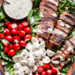 Caprese Grilled Chicken Salad on wood platter
