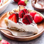 Chocolate Drizzle Strawberries and Almond Cream Pie sliced on wooden plate