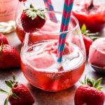 Strawberry Sorbet Rosé Floats in glass with straw and strawberry garnish