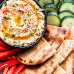 Grilled Baba Ganoush on plate with cucumbers, pita and red bell peppers.
