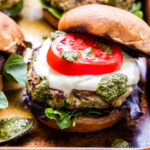 Pesto Zucchini Turkey Burger topped with fresh mozzarella a tomato and pesto