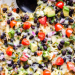 Green Chile Chicken Enchilada Quinoa Casserole topped with tomatoes, avocado, cheese, red onions.