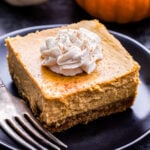 Creamy Pumpkin Pie Bar on a black plate with a fork.