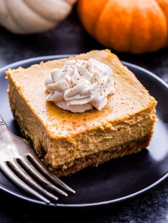 Creamy Pumpkin Pie Bar on a black plate with a fork.