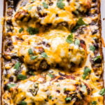 Salsa Verde Baked Chicken on top of black beans and corn. Topped with melted cheese in a casserole dish.