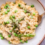 Lemon Asparagus Risotto with peas in a white bowl.