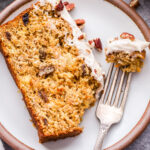 Slice of Oatmeal Carrot Cake Bread on white plate with a piece broken off and on a fork