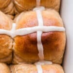 Closeup of a Hot Cross Bun topped with a white icing cross.