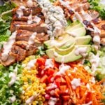 buffalo chicken salad drizzled with spicy ranch dressing on a white serving platter.