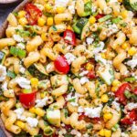 overhead photo of Tomato Corn Pasta Salad in a white serving bowl.