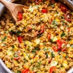 Southwest Turkey Vegetable and Rice in a stainless steel skillet with a wooden spoon in it.