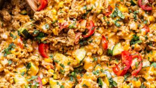 Southwest Turkey Vegetable and Rice in a stainless steel skillet with a wooden spoon in it.