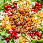 Honey Lime Shrimp Salad on a serving platter. Salad is topped with tomatoes, avocado, corn and queso fresco.