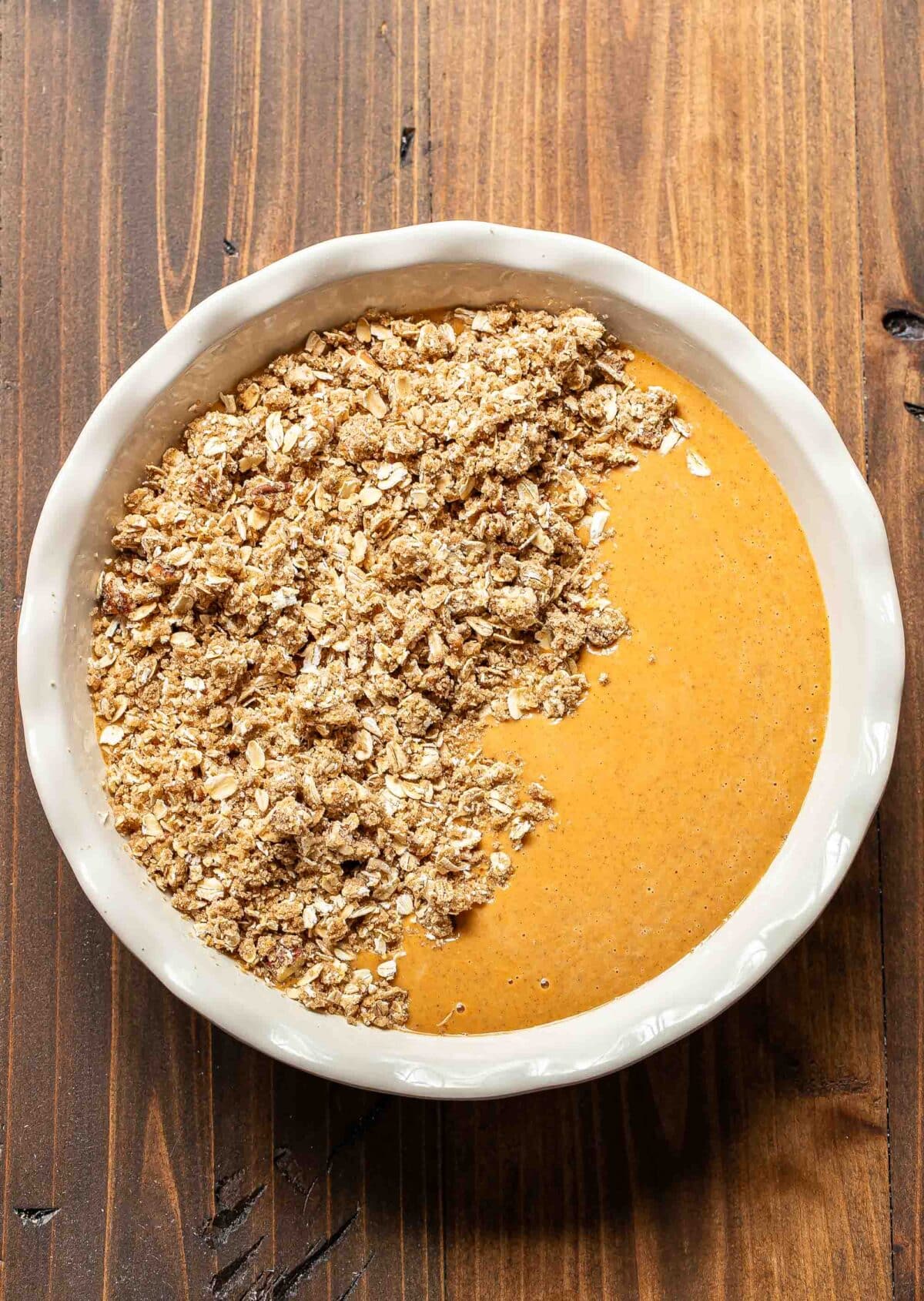 Pumpkin crisp in a white pie dish before it's been baked.
